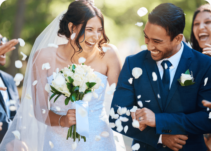 Happy bride and groom, flower petals.
