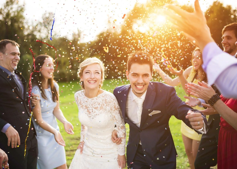 A bride and groom are surrounded by friends.